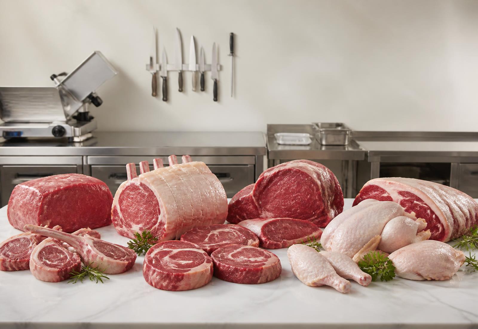 Premium Rind-, Lamm- und Geflügelteile auf Marmor in einer professionellen Fleischerei
